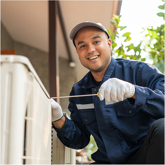 Brookside hvac technician repairing hvac unit in backyard of home wearing blue suit and smiling