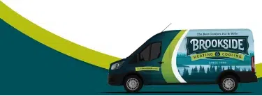 family of 4 posing while sitting on porch with large white fluffy dog smiling in front of grey siding and brown front door